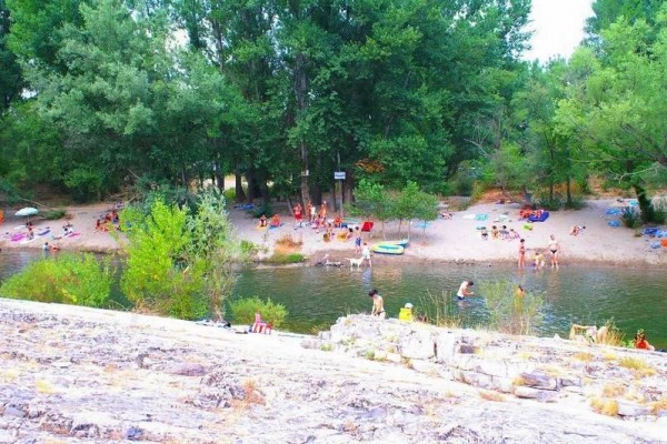 Plage du camping Val d'Hérault en bord de rivière avec piscine